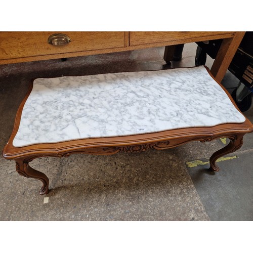 1010 - A carved wood and marble top coffee table.