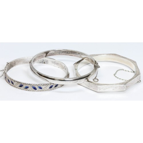 194 - Two hallmarked silver hinged bangles and another marked '925', gross weight 38.6g.