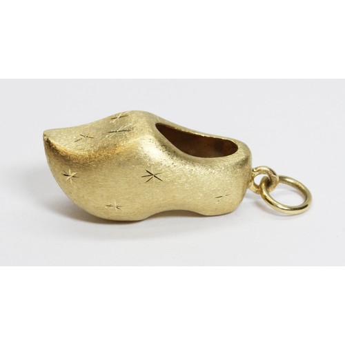 6 - A novelty charm modelled as a clog, textured finish, marked '750', length 37mm, weight 3.9g.