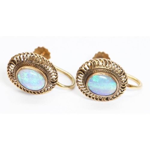 29 - A pair of opal cabochon earrings, filigree border, screw backs marked '14K', head measuring 11mm x 1... 