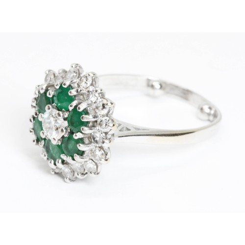 151 - A mid 20th century diamond and emerald cocktail ring, the central round brilliant cut stone weighing... 