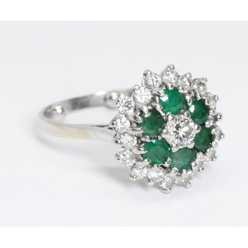 151 - A mid 20th century diamond and emerald cocktail ring, the central round brilliant cut stone weighing... 