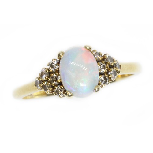 164 - An 18ct yellow gold opal and diamond ring, the central oval cabochon measuring approximately 8.10mm ... 