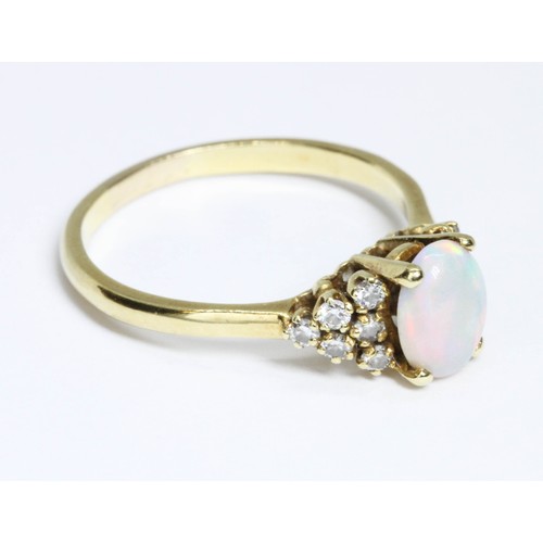 164 - An 18ct yellow gold opal and diamond ring, the central oval cabochon measuring approximately 8.10mm ... 