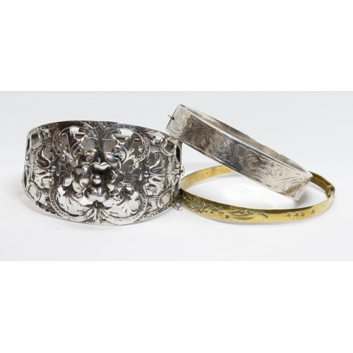 519 - A group of three bangles comprising one of floral design unmarked, one hallmarked silver and another... 