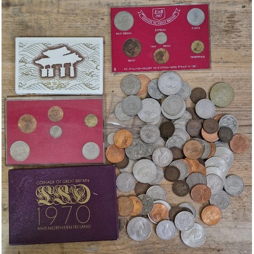 568 - A tub of assorted world coins to include commemorative crowns, half crowns & various coin sets etc.