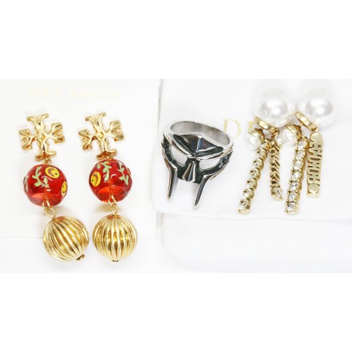 615 - Costume jewellery comprising an 'MF Doom' ring, a pair of Tory Burch earrings and a pair of 'Dior' e... 