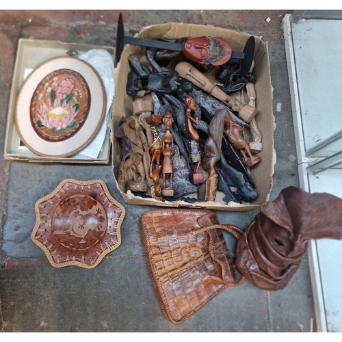 68 - A box of assorted African items to include carved wooden figures and leather items etc.