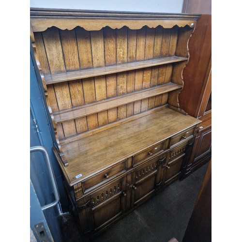 878 - A reproduction oak dresser, width 139cm, depth 44cm & height 178cm.