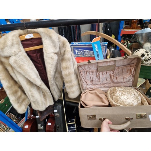 159 - A suitcase with vintage ladies hats and faux fur jacket.