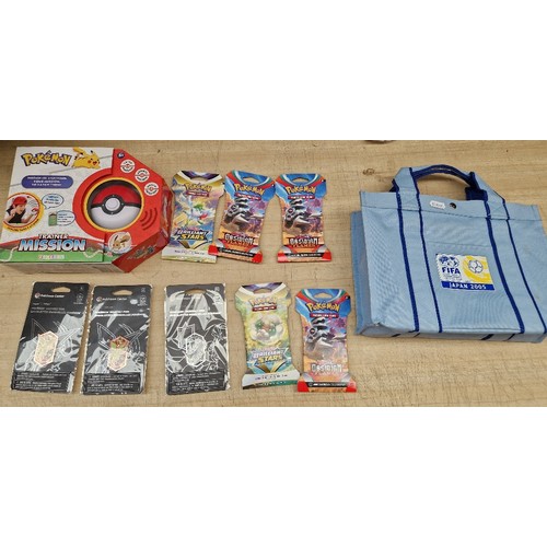 133 - A Fifa Japan 2005 bag with contents of assorted Pokemon items to include sealed card packs, badges &... 