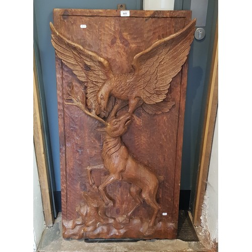 841 - A large carved wooden relief wall plaque depicting an eagle attacking a stag, 59cm x 111cm.