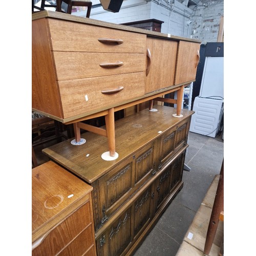 936 - A mid 20th century teak sideboard together with an oak linenfold side cabinet.