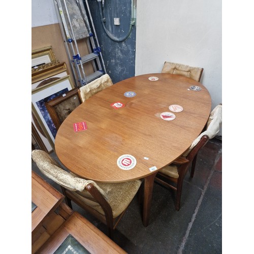 932 - A mid 20th century teak extending dining table and four chairs.