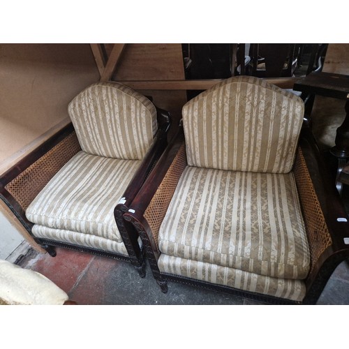 926 - A pair of early 20th century carved wood & bergere armchairs.