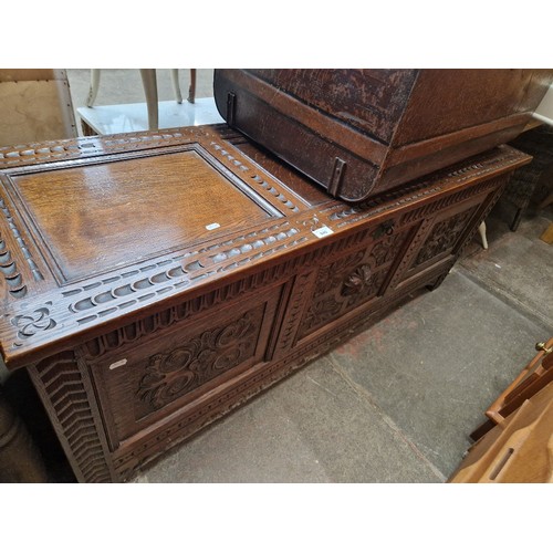 940 - A carved oak coffer, length 145cm.