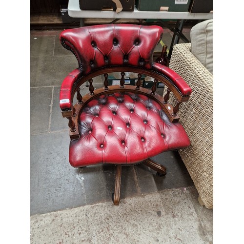 989 - An oxblood red leather Chesterfield captain's chair.