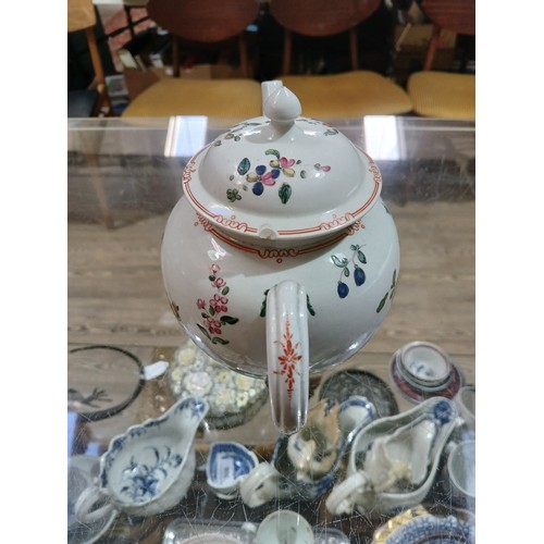 305 - A bow porcelain teapot circa 1760, decorated in floral over enamels, length 19cm.