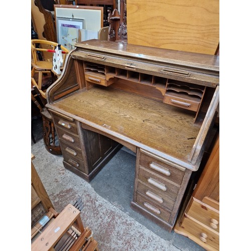 969 - An early 20th century oak roll top desk, width 122cm.