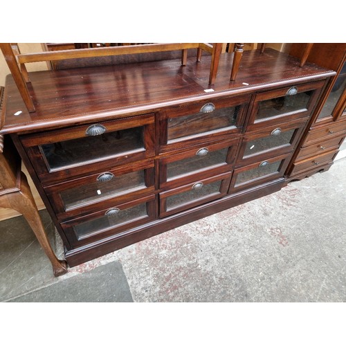 976 - A haberdashery style mahogany bank of drawers/sideboard with glass fronts to the drawers.