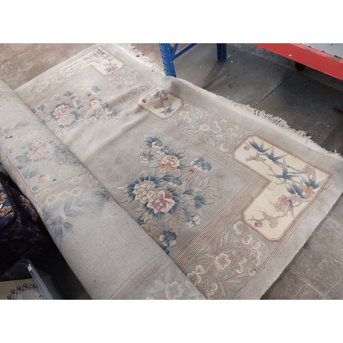 1011 - A large Chinese wool carpet decorated with flowers and birds, width 273cm.