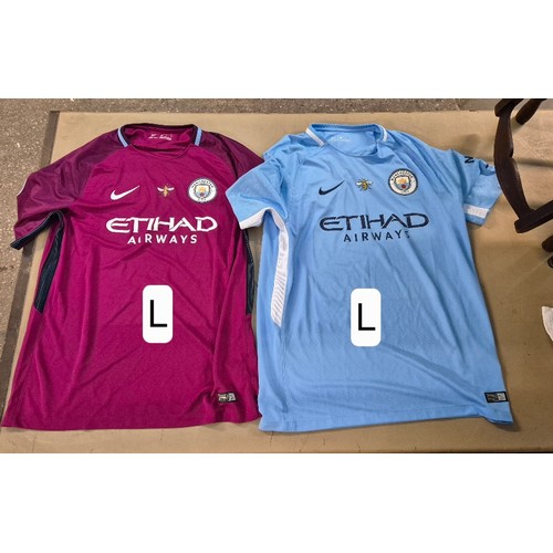 219 - A box of Manchester City Football Club shirts, tops and scarves.