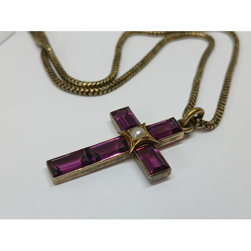 113 - A Victorian garnet and split pearl cross pendant, length 34mm, on 38cm smooth snake link chain, both... 