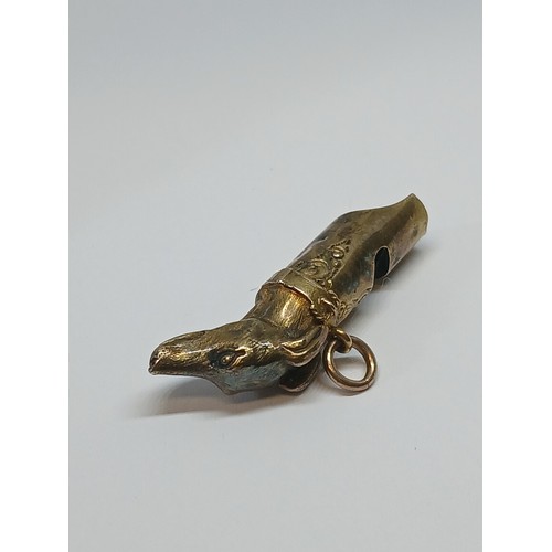 80 - A Victorian yellow metal whistle modelled as a dog's head, length 38mm, unmarked, weight 2.8g.