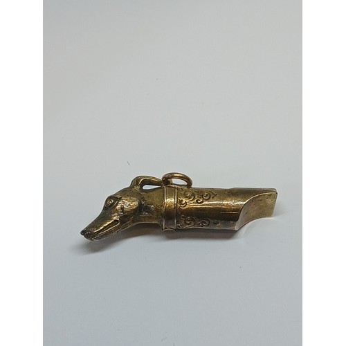 80 - A Victorian yellow metal whistle modelled as a dog's head, length 38mm, unmarked, weight 2.8g.