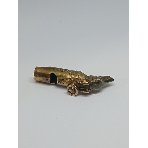 80 - A Victorian yellow metal whistle modelled as a dog's head, length 38mm, unmarked, weight 2.8g.