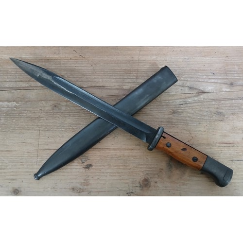 30 - A German Third Reich K98 bayonet, blade length 24.5cm, wooden grip, metal scabbard, total length 40.... 