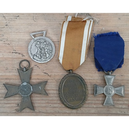 92 - Four German Third Reich WWII medals comprising Westwall, 2nd class War Merit Cross, Long Service Cro... 