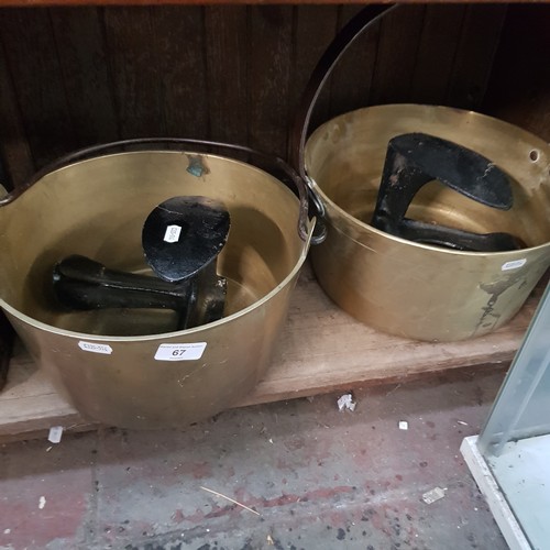 67 - Two brass jam pans and two cast iron shoe lasts.