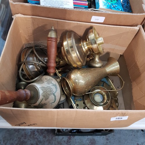 389 - A box of metalware including brass bells, jugs etc