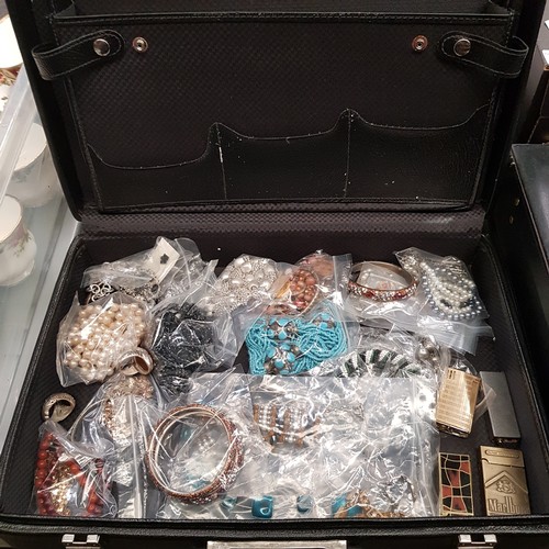 435 - A briefcase of assorted costume jewellery and lighters