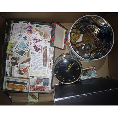 330 - A box of assorted collectables including various badges, cigarette cards etc.