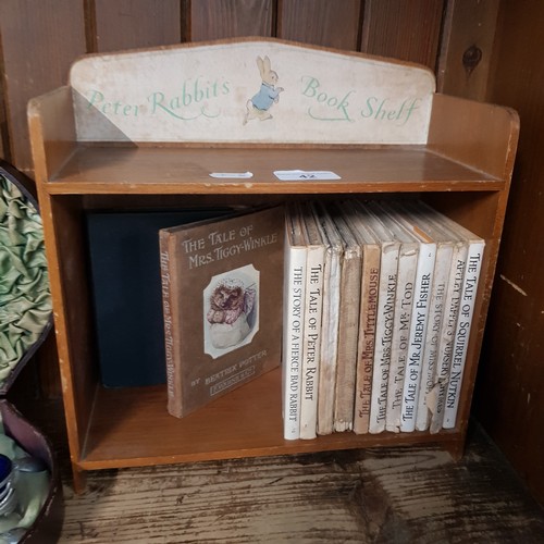 42 - Peter Rabbit Book Shelf with fourteen Beatrix Potter books.