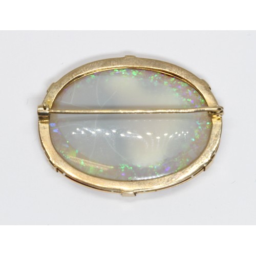 14 - AN ANTIQUE OPAL BROOCH, the double sided oval opal cabochon measuring approximately 35mm x 26mm and ... 