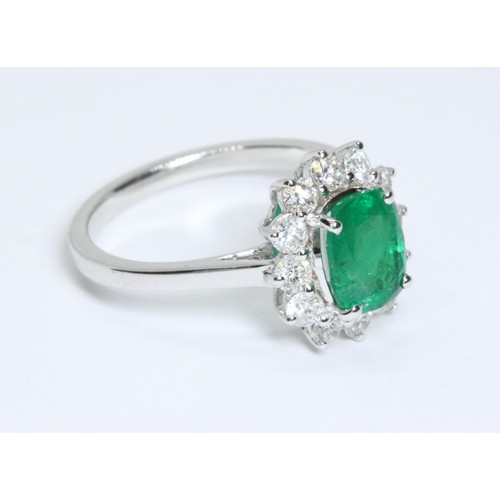 17 - A diamond and emerald cluster ring, the central cushion cut emerald weighing approximately 1.40ct, s... 