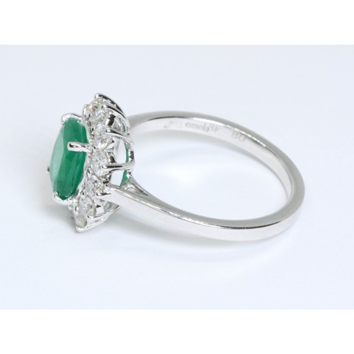 17 - A diamond and emerald cluster ring, the central cushion cut emerald weighing approximately 1.40ct, s... 