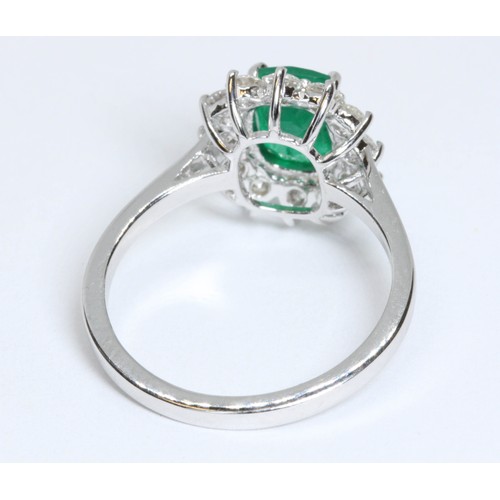 17 - A diamond and emerald cluster ring, the central cushion cut emerald weighing approximately 1.40ct, s... 