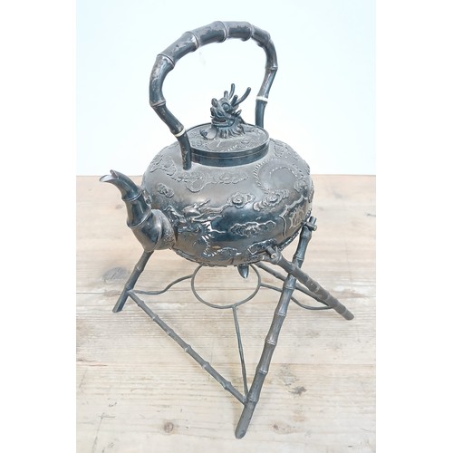 182 - A Chinese silver spirit kettle, decorated with clouds and two dragons, bamboo handle, spout and stan... 