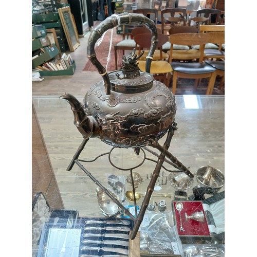 182 - A Chinese silver spirit kettle, decorated with clouds and two dragons, bamboo handle, spout and stan... 