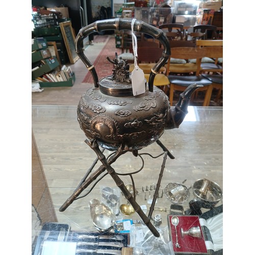 182 - A Chinese silver spirit kettle, decorated with clouds and two dragons, bamboo handle, spout and stan... 