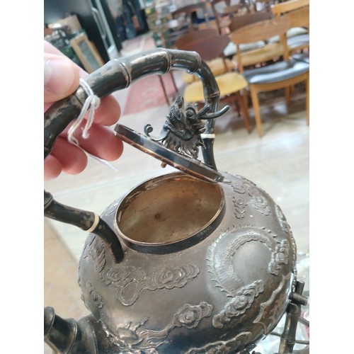 182 - A Chinese silver spirit kettle, decorated with clouds and two dragons, bamboo handle, spout and stan... 