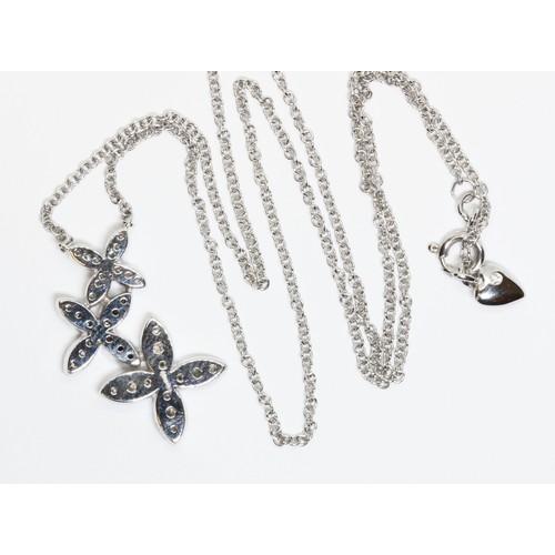 34 - DAVID M ROBINSON, an 18ct white gold diamond pendant, three graduated flower clusters set with thirt... 