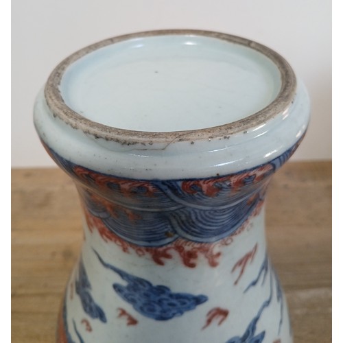 614 - A Chinese porcelain baluster vase decorated in red and blue underglaze depicting a dragon amongst cl... 