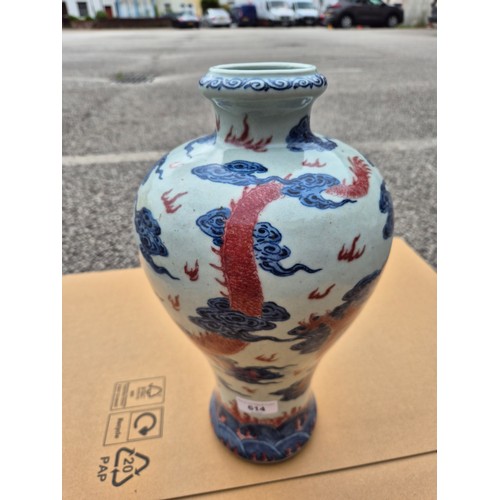 614 - A Chinese porcelain baluster vase decorated in red and blue underglaze depicting a dragon amongst cl... 