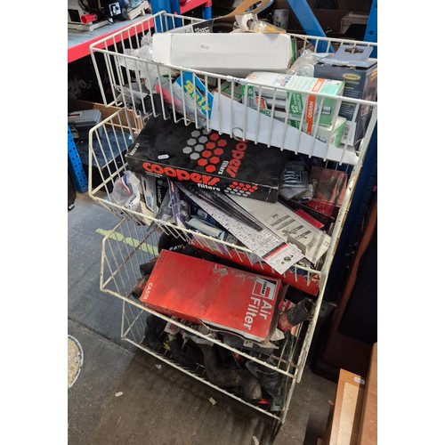 A four tiered shop display unit containing assorted car parts