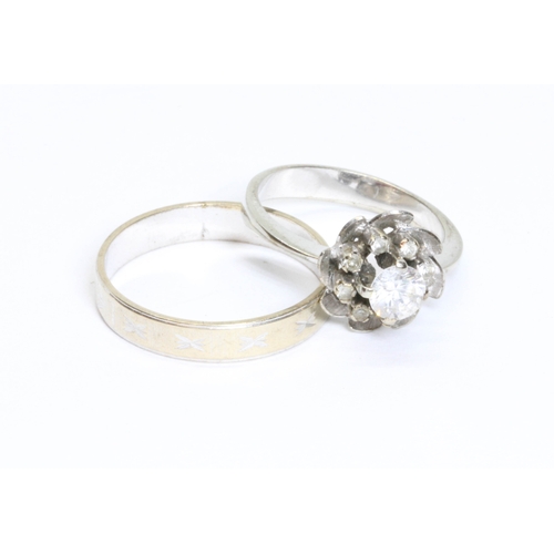 Two white metal rings, one set with colourless stones, indistinct ...